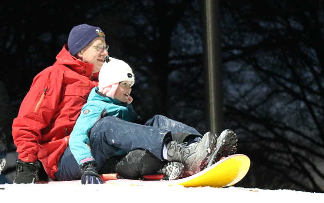 dad and daughter sledding together